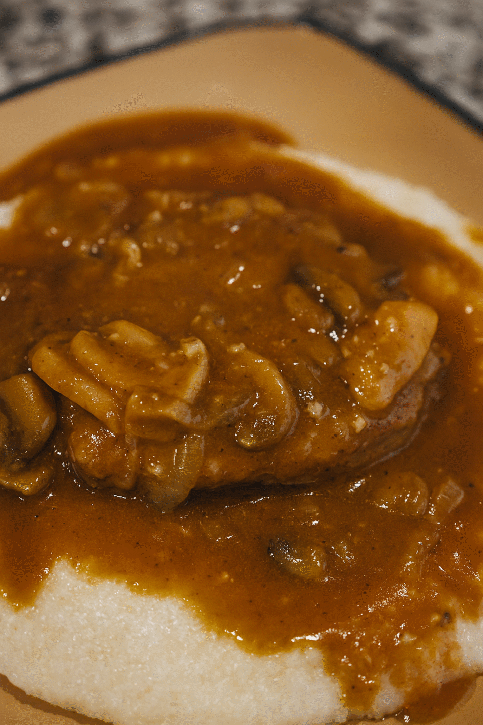 Pork chop smothered in Mushroom and Onion Gravy over Grits